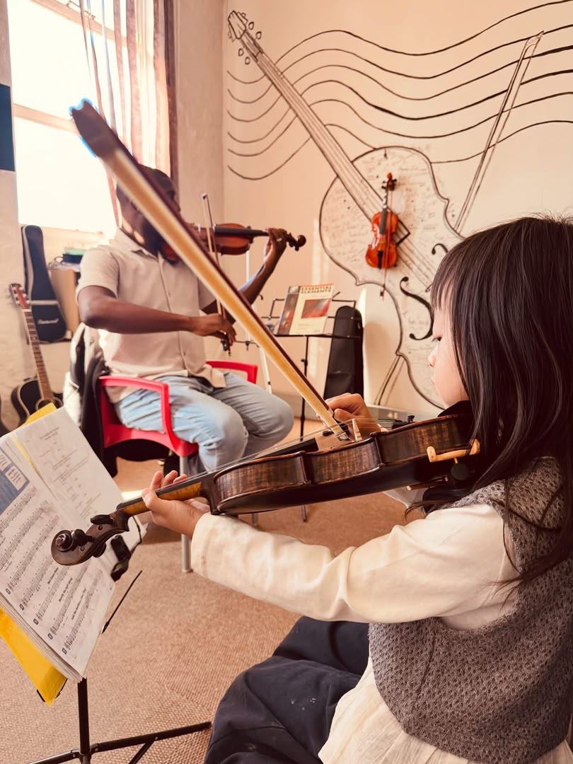 Instructor teaching a young violin student